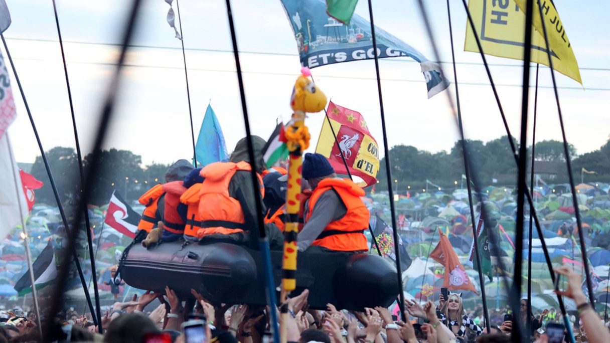 The migrant boat appeared above the crowd during Lil Simz's set. Pic: AP/Celebrity Photos UK/Cover Images